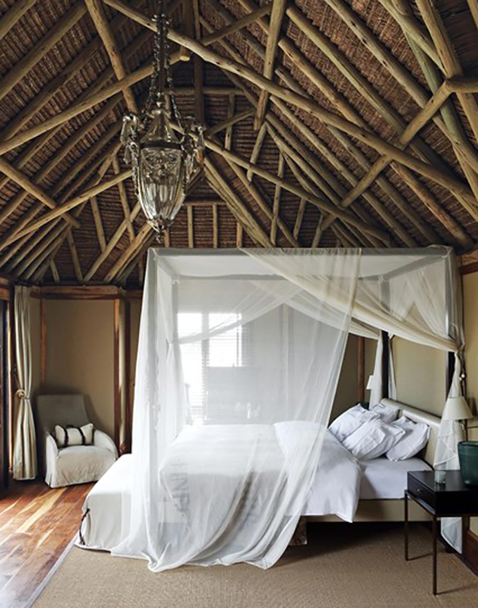 Plafond haut en poutres apparente et lit baldaquin de voile blanc